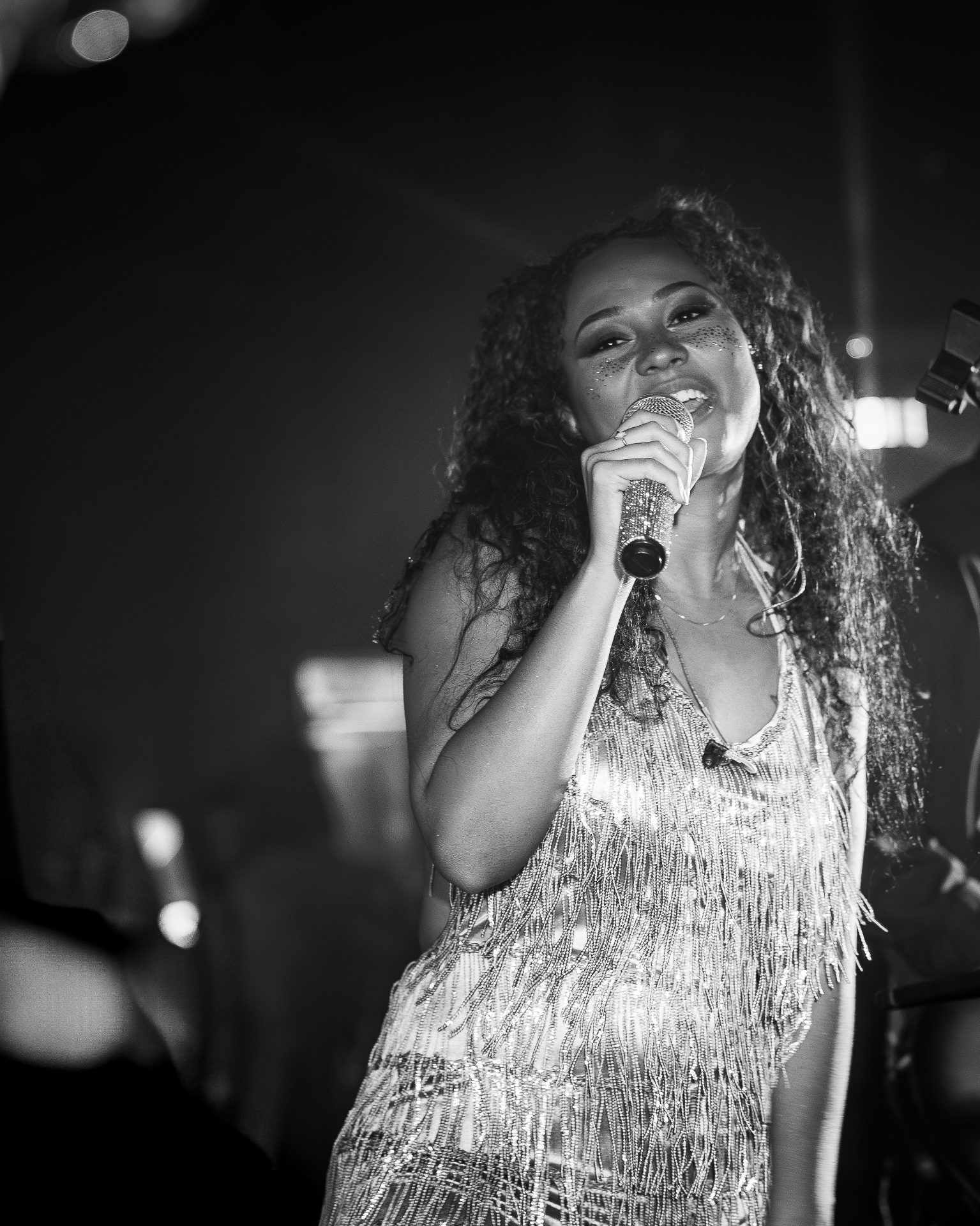 Manix Rho singer in fringe dress performing on stage