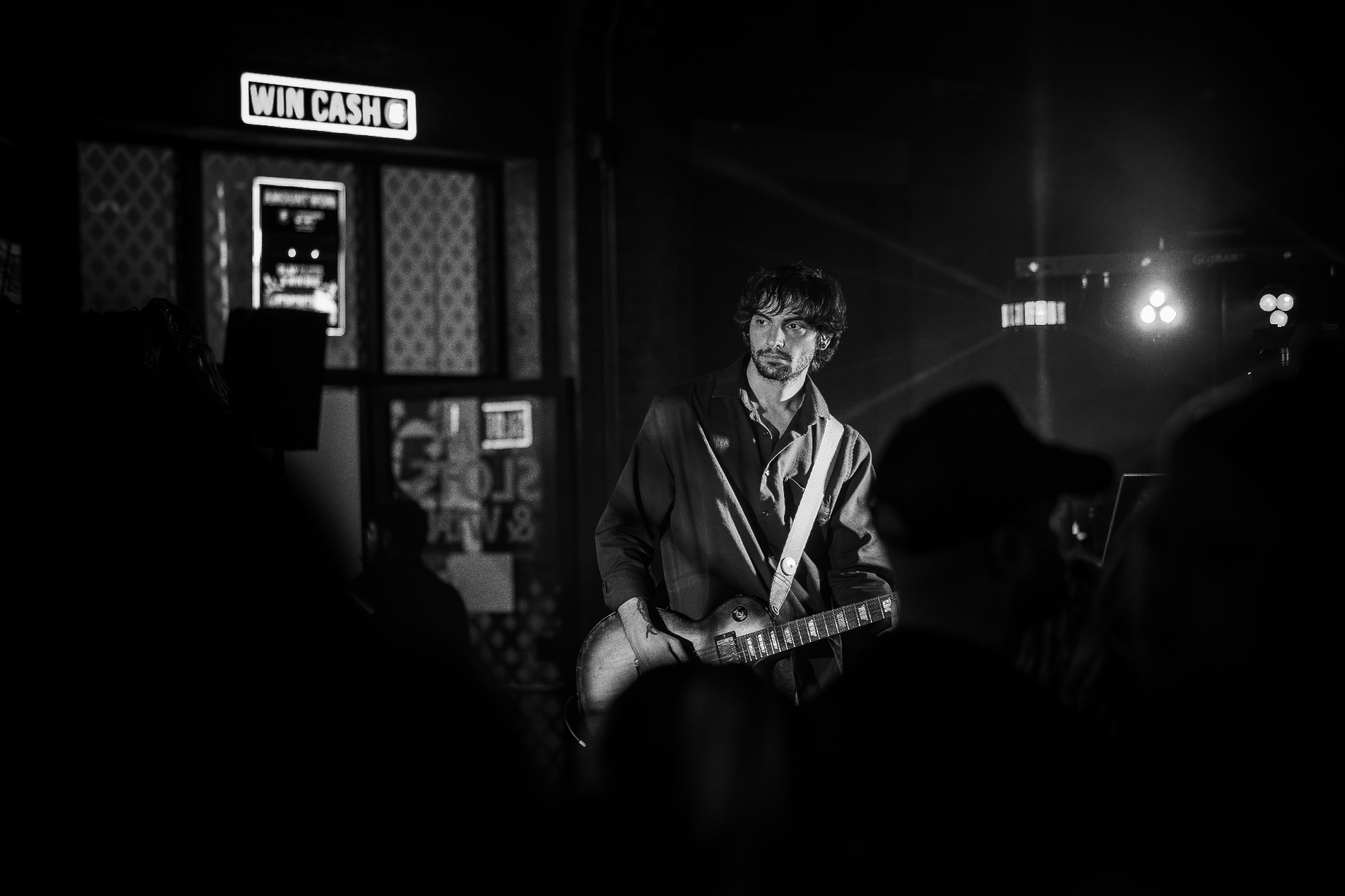 Manix Rho guitarist on stage with Les Paul under stage lights